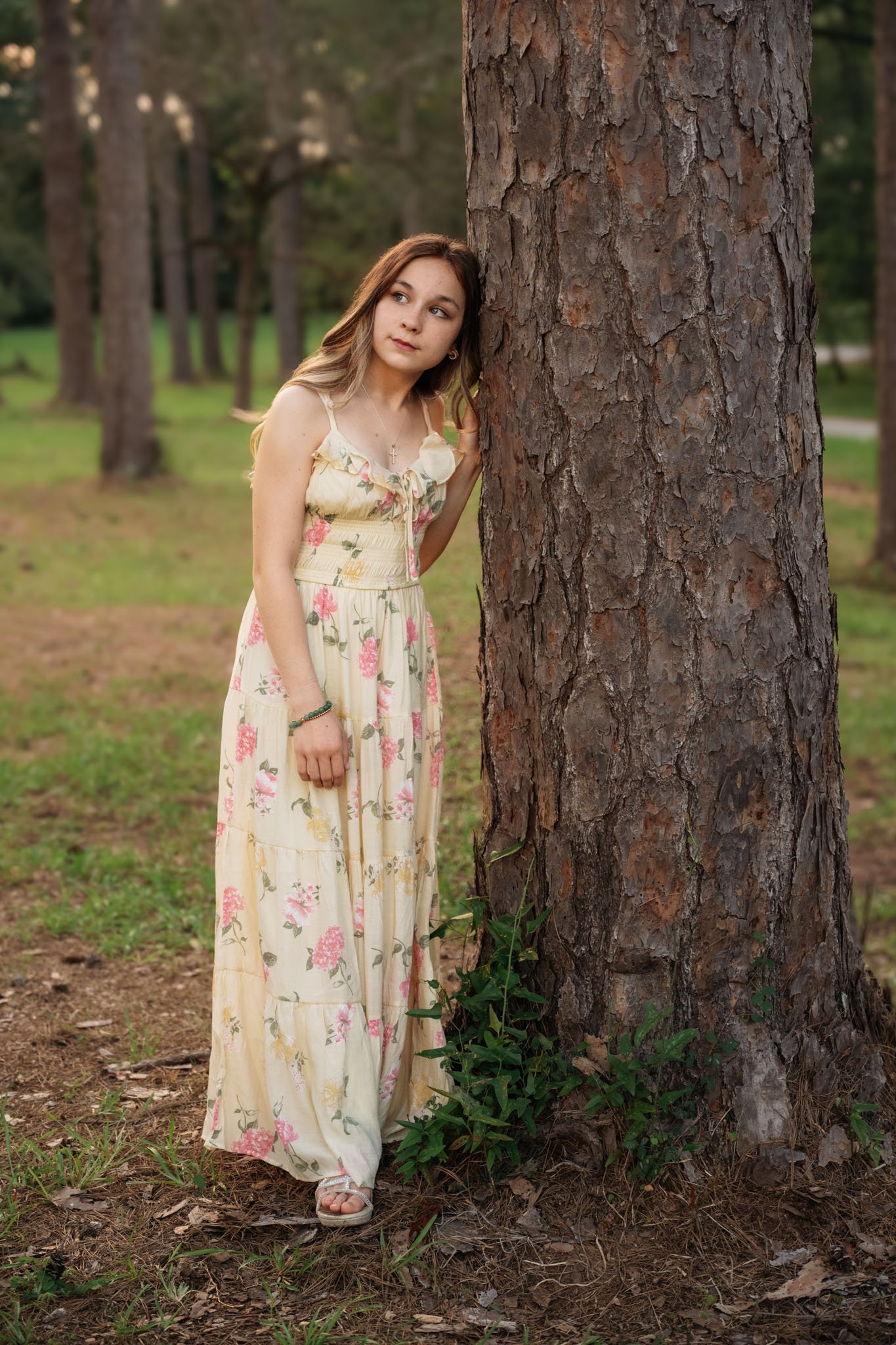 girl leaning against tree in a park