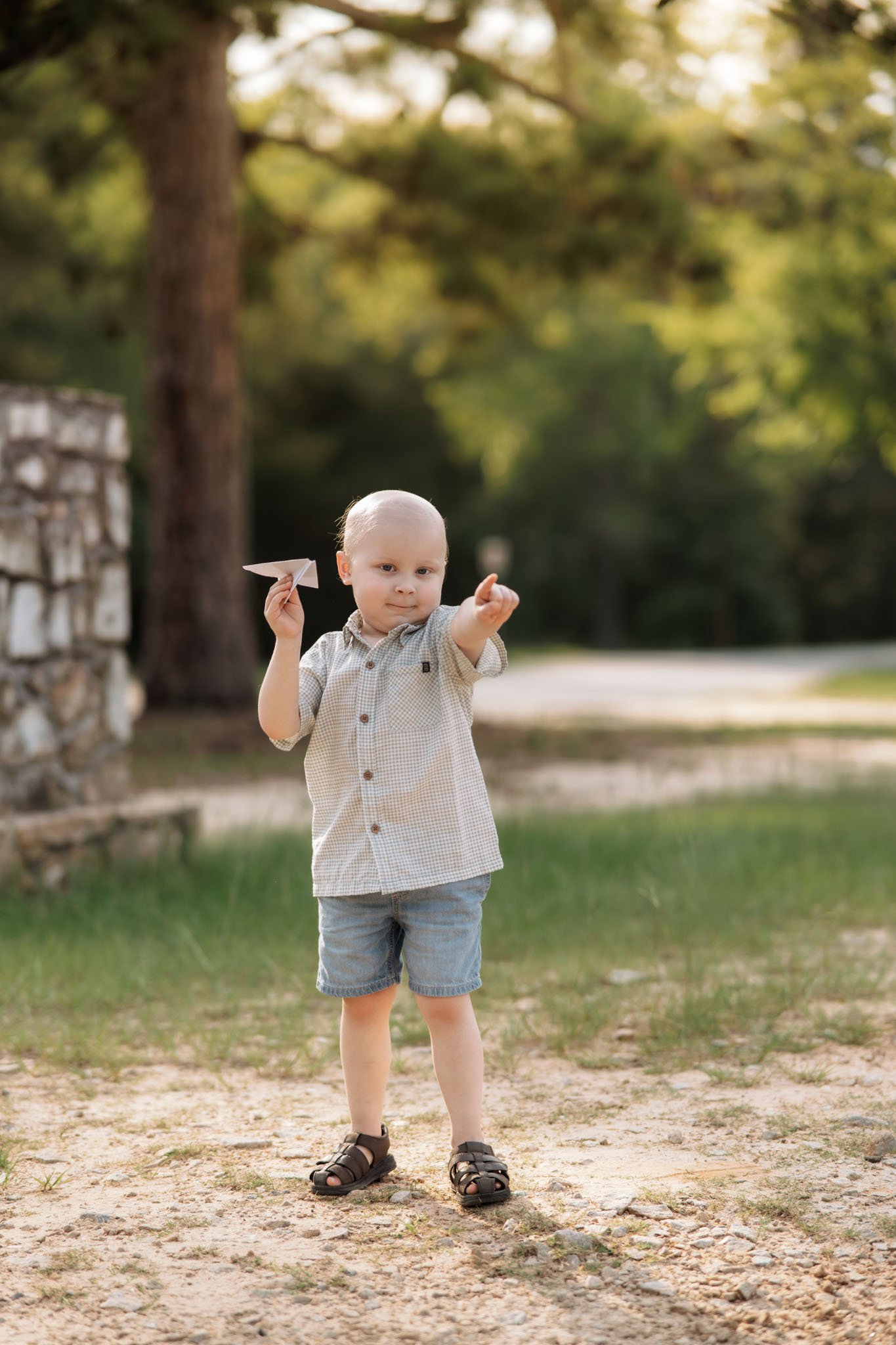little boy throwing a paper airplane